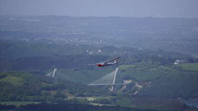 Modellflugzeug in der Luft über der Brücke Pont Terenez in der Bretagne